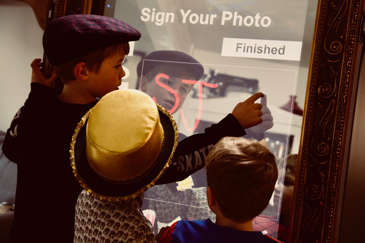 Image shows - a young guest personalising their prints with the Magic Selfie Mirror