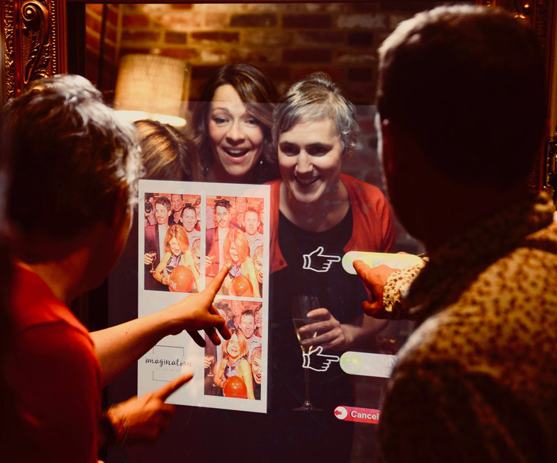 Image shows - party guests selecting their images in front of the Magic Selfie Mirror