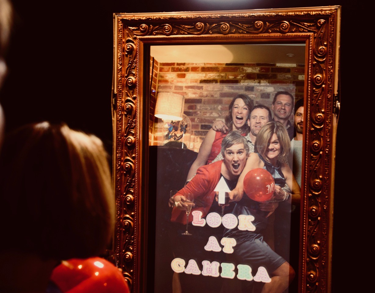 Image shows - party guests posing in front of the Magic Selfie Mirror